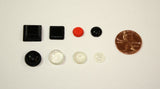 8 individual bump dots of assorted colors, shapes and sizes shown next to a penny on a white background.  The largest is about the size of a penny.