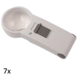 White, round lens hand held magnifier with grey on/off switch on rectangular handle labeled 7x.