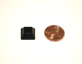 Individual black, square bump dot shown next to a penny which is similar in size.
