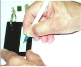 Hand holding pen using black keychain signature guide.