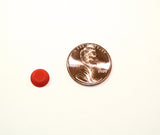 Individual medium sized orange, round flat top bump dot next to a penny. The bump dot is 1/4 the size of a penny. 